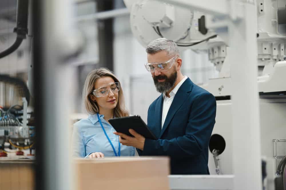 female,engineer,and,male,supervisor,standing,in,modern,industrial,factory,