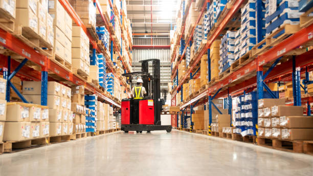 a worker is operating forklifts in the warehouse passageway